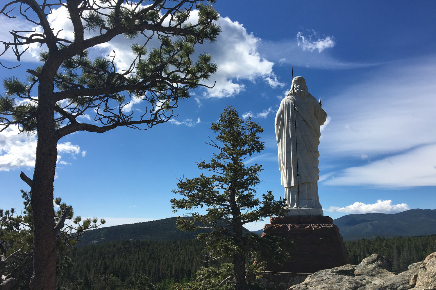 A statue of Christ and a World War II memorial overlooks the Chapel on the Rock, formally named St. Catherine of Siena Chapel in Allenspark, Colorado, near Estes Park, is seen June 19, 2019. The chapel is on the grounds of the Camp St. Malo Retreat Center, which was made famous during St. John Paul II’s epic World Youth Day visit to the Denver in 1993.